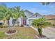 Inviting home exterior with lush landscaping, palm trees, and a vibrant red front door at 3455 Bellingham Dr, Orlando, FL 32825