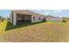 Spacious backyard view, including a screened lanai, lush green grass, and a privacy fence at 4115 Ruby Run, Haines City, FL 33844