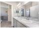 Bathroom showcasing double sinks with a marble countertop, complemented by a view into an adjacent bedroom at 4115 Ruby Run, Haines City, FL 33844