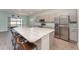 Bright kitchen with stainless steel appliances, spacious island with seating, and modern gray cabinets at 4115 Ruby Run, Haines City, FL 33844