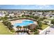 Aerial view of a community pool area, complete with palm trees, lounge chairs, and a spacious pool deck at 4115 Ruby Run, Haines City, FL 33844