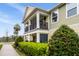 Two-story townhouse with balconies, light green and beige exterior paint, and lush landscaping at 465 Gee Hammock Ln, Winter Springs, FL 32708