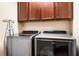 Laundry room with gray washer and dryer, upper wood cabinets and ironing board at 465 Gee Hammock Ln, Winter Springs, FL 32708