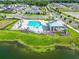 Aerial view of a community pool and clubhouse near a lake and surrounded by residential homes at 5266 Buttonsage Dr, St Cloud, FL 34772