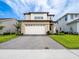 Attractive two-story home with a large driveway, well-maintained lawn, and neutral color scheme at 5266 Buttonsage Dr, St Cloud, FL 34772