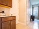 Hallway with access to the laundry room with wooden cabinets at 5266 Buttonsage Dr, St Cloud, FL 34772