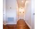 Hallway with wooden floors and a minimalist aesthetic featuring white doors and neutral-toned walls at 5266 Buttonsage Dr, St Cloud, FL 34772