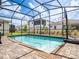 Backyard pool with a basketball hoop and a brick patio enclosed within a screened enclosure at 5266 Buttonsage Dr, St Cloud, FL 34772