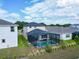 View of a home's backyard featuring an enclosed pool and well-kept green lawn, surrounded by other houses at 5266 Buttonsage Dr, St Cloud, FL 34772