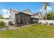 Exterior view of a backyard with a screen patio, fire pit, privacy fence and solar panels on the roof at 5276 Rocking Horse Pl, Oviedo, FL 32765