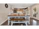 Warm dining space featuring wood table, seating bench, and natural light with seamless flow to adjacent kitchen at 5276 Rocking Horse Pl, Oviedo, FL 32765