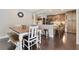 Open dining area with wood table, seating bench, kitchen access, and modern design with sleek, dark flooring at 5276 Rocking Horse Pl, Oviedo, FL 32765