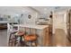 Kitchen island with breakfast bar seating, modern faucet, and seamless flow to dining and living areas at 5276 Rocking Horse Pl, Oviedo, FL 32765