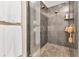 Modern walk-in shower with gray stone tile, dual showerheads, and glass enclosure at 5276 Rocking Horse Pl, Oviedo, FL 32765