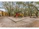 Community playground with slides and swings, surrounded by mature trees at 5291 Images Cir # 302, Kissimmee, FL 34746