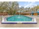 Inviting community pool surrounded by mature trees and featuring ample seating at 5291 Images Cir # 302, Kissimmee, FL 34746