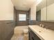 Bathroom with a tiled shower-tub, a toilet and a sink with a gray tiled wall at 5513 Riordan Way, Orlando, FL 32808