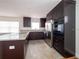 Modern kitchen featuring dark cabinets, granite counters, and stainless steel appliances at 5513 Riordan Way, Orlando, FL 32808