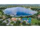 Aerial view of the community featuring tennis courts, a clubhouse, a pool, and a serene lake at 7213 Greenville Ct, Orlando, FL 32819