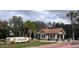 Community entrance features a sign reading 'Orange Tree' with lush landscaping and a covered entrance booth at 7213 Greenville Ct, Orlando, FL 32819