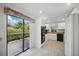 Modern kitchen with white cabinetry, stainless steel appliances, and a view of the backyard through sliding doors at 7213 Greenville Ct, Orlando, FL 32819