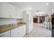 Bright kitchen with granite countertops, white cabinets, and an open layout to the living area at 7213 Greenville Ct, Orlando, FL 32819