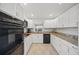 Well-lit kitchen with white cabinets, granite countertops, stainless steel appliances, and tile flooring at 7213 Greenville Ct, Orlando, FL 32819