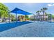 Outdoor playground area features colorful play equipment, a blue canopy for shade, and a soft blue rubber surface at 7213 Greenville Ct, Orlando, FL 32819