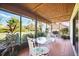 Inviting screened porch with views of the backyard, a ceiling fan, and a glass table at 7213 Greenville Ct, Orlando, FL 32819