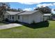 This home includes an attached garage and features a well-maintained lawn, shrubs, and a simple bench at 820 Dove Ridge Dr, Lakeland, FL 33803