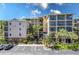 Multi-story condo building with balconies, palm trees and parking at 9051 Treasure Trove Ln # 505, Kissimmee, FL 34747