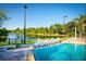 Community pool with lake view and lounge chairs for residents to enjoy at 9051 Treasure Trove Ln # 505, Kissimmee, FL 34747