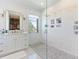 Bright bathroom with marble tile, a glass shower, a large vanity, and a window at 9138 Bay Point Dr, Orlando, FL 32819