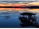 Picturesque dock on a serene lake reflecting a vibrant sunset at 9138 Bay Point Dr, Orlando, FL 32819