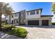 Modern two-story home boasting a three-car garage and manicured landscaping at 9138 Bay Point Dr, Orlando, FL 32819