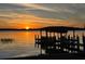 Scenic waterfront view featuring a private dock and a sunset over the tranquil waters at 9138 Bay Point Dr, Orlando, FL 32819