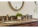 Bathroom vanity featuring dual sinks, ornate mirrors, and dark granite counters at 105 Norris Pl, Casselberry, FL 32707