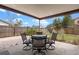 Back patio perfect for outdoor dining with a metal table and chair set beneath a covered space and fenced backyard at 1080 Abell Cir, Oviedo, FL 32765