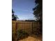 Backyard at dusk featuring a wooden fence, potted plants, and orange flowers at 1080 Abell Cir, Oviedo, FL 32765