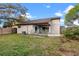 Backyard view features a covered patio, green grass, and a wooden fence at 1080 Abell Cir, Oviedo, FL 32765