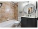 Bathroom featuring a tub-shower combo with tiled walls and a vanity with a decorative mirror and updated hardware at 1080 Abell Cir, Oviedo, FL 32765