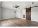 A spacious bedroom with wood-look tile flooring, a ceiling fan, and a barn door leading to the bathroom at 1080 Abell Cir, Oviedo, FL 32765