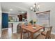 Dining room showcasing the adjacent kitchen, modern lighting, and a view of the front yard at 1080 Abell Cir, Oviedo, FL 32765