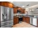 Modern kitchen featuring stainless steel appliances, tile floors, and warm wood cabinets at 1080 Abell Cir, Oviedo, FL 32765