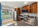 Updated kitchen featuring stainless steel appliances, warm wood cabinets, and tile flooring at 1080 Abell Cir, Oviedo, FL 32765