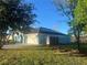 Exterior of a home with a 2 car garage and solar panels, with a grassy back yard at 10800 Cherry Oak Cir, Orlando, FL 32817