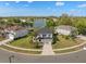 Beautiful aerial view of a home with a well-kept lawn, surrounded by lush greenery and a tranquil lake, perfect for serene living at 12621 Oulton Cir, Orlando, FL 32832