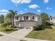Charming two-story home featuring an attached two-car garage and a well-maintained lawn with tropical landscaping at 12621 Oulton Cir, Orlando, FL 32832