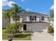 Charming two-story home featuring a two-car garage, well-maintained lawn and lush palm trees, creating a welcoming curb appeal at 12621 Oulton Cir, Orlando, FL 32832