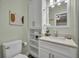 Bathroom with white fixtures including vanity with storage, toilet, a stylish mirror and decor at 1416 E 20Th St, Sanford, FL 32771